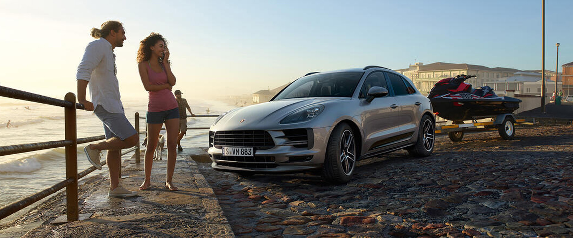 couple standing beside porsche