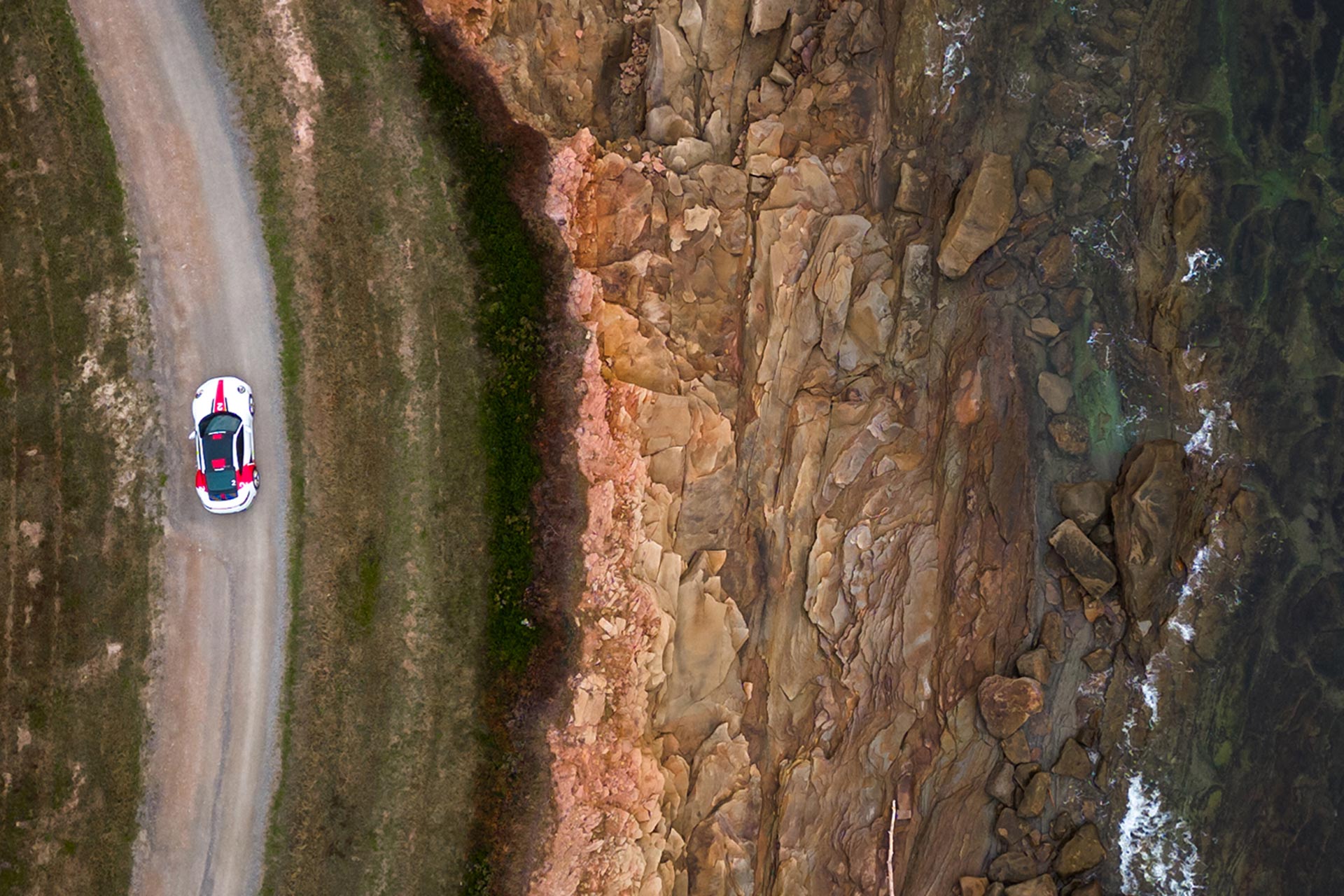 porsche 911 driving along coastal road