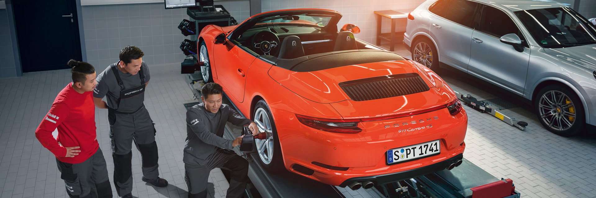 workers working on porsche